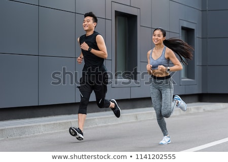 ストックフォト: Handsome Man And Beautiful Woman Jogging Together On Street Betw