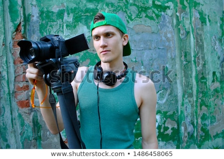 Foto stock: Smiling Young Guy Hanging Headphones In His Neck