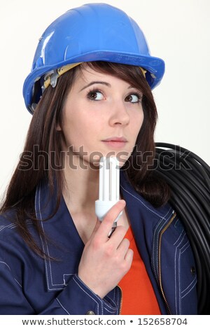 Zdjęcia stock: Thoughtful Woman Holding A Compact Fluorescent Lamp