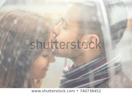 [[stock_photo]]: Young Couple Kissing Under The Rain With Transparent Umbrella  