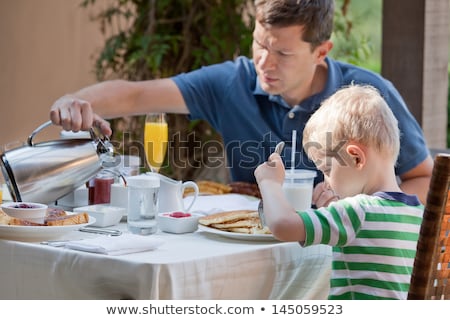 Сток-фото: Family Of Two Eating Nicely Served Breakfast Outside Handsome Young Man Pouring Some Coffee And His