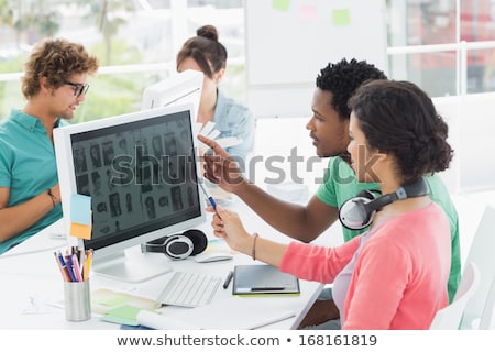 Сток-фото: Side View Of Young Mixed Race Female Graphic Designer Working On Graphic Tablet At Desk In A Modern