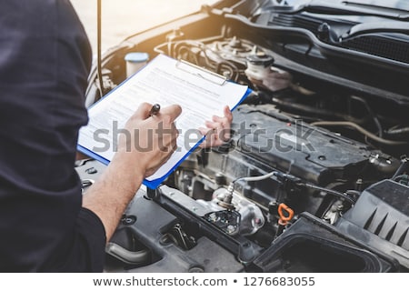 Stock photo: Auto Mechanic With Oil And Clipboard At Car Shop