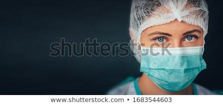 Stok fotoğraf: Young Doctor Wearing Mask And Medical Cap