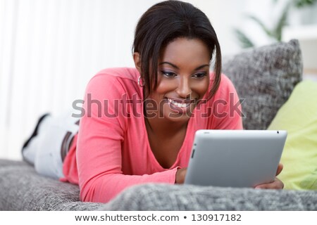 Сток-фото: Happy Smiling Black Woman On Sofa Surfing Internet
