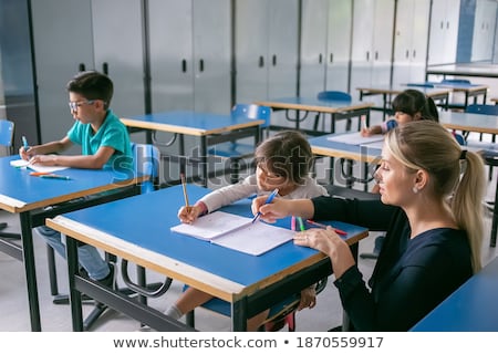 Stok fotoğraf: Teacher Helping Elementary School Pupils With Their Tasks