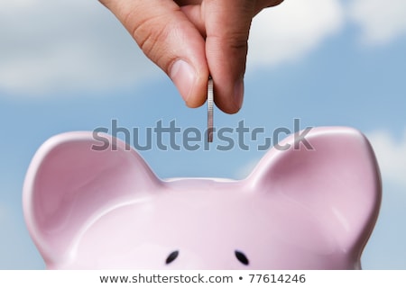 Foto d'archivio: Saving Money In Piggy Bank With Fingers