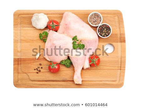 Foto d'archivio: Raw Chicken Leg On A Wooden Board With Spices And Vegetables
