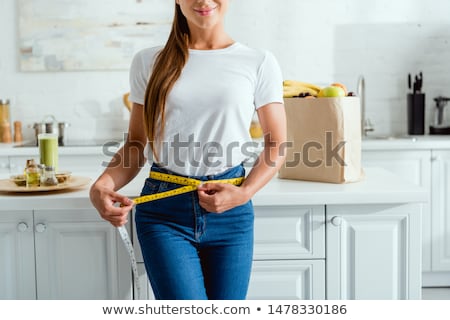 Stock photo: Woman Measuring Waist With A Tape Measure