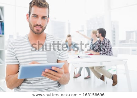 Stock photo: Business Man Works In Office With Tablet In The Foreground Concept Of Teamwork And Partnership Dou