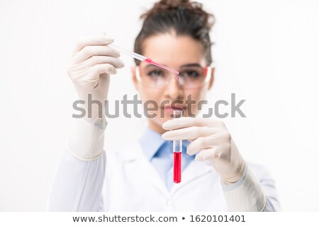 Foto stock: Young Female Chemist In Gloves Dropping Red Liquid Substance Into New Vaccine