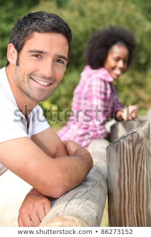 ストックフォト: Couple Leaning Against A Wooden Barrier