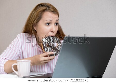 Stok fotoğraf: Woman Eating Sesame Bagel For Breakfast In Office Top View