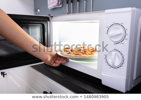Foto stock: Woman Baking Pizza In Microwave Oven