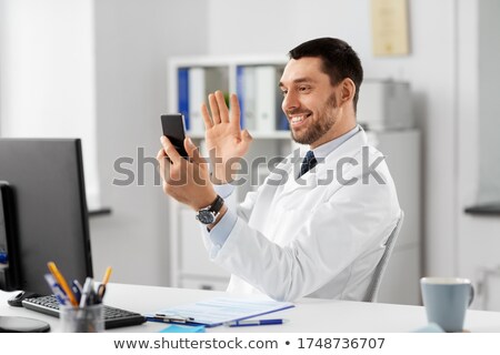 Foto d'archivio: Man With Smartphone Having Video Call At Office