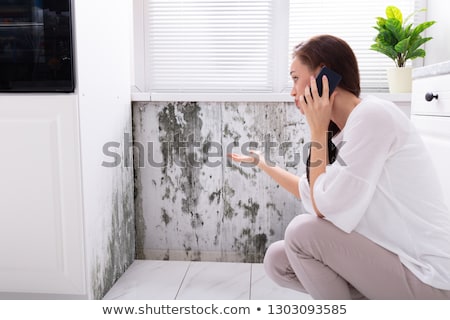 Zdjęcia stock: Woman Calling For Assistance Near Damaged Wall