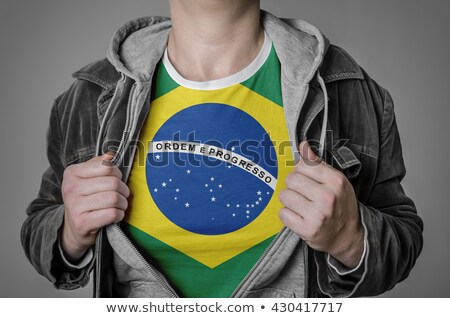 Foto stock: Man Stretching Jacket To Reveal Shirt With Brazil Flag
