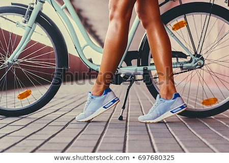 Zdjęcia stock: Legs Of A Woman In Sneakers With A Bicycle Close Up