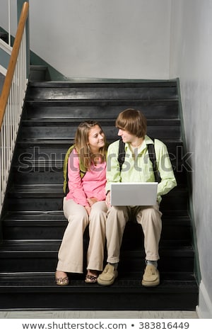 Foto stock: Couple Sat In Steps With Laptop