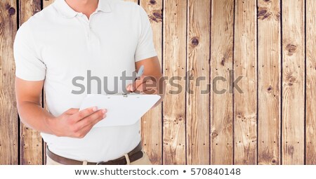 ストックフォト: Delivery Man Writing On Clipboard Against Wooden Background
