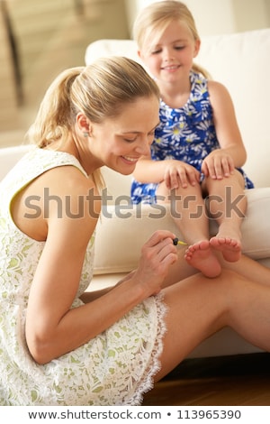 Foto stock: Mother Painting Toenails Of Two Girls