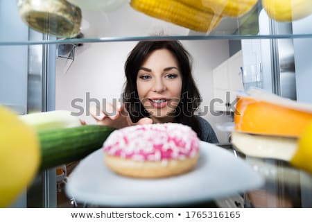 Zdjęcia stock: Happy Young Woman Taking Donut From Refrigerator