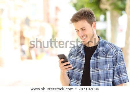 Stock foto: Young Boy Holding Cellular Phone And Smiling