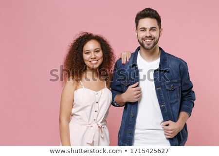 ストックフォト: Smiling Curly Woman In Denim Clothes Posing With Arm Together