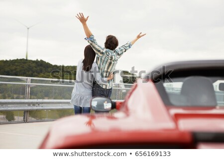 Foto stock: Couple Close Together Near Electric Car