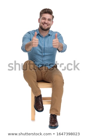 Foto stock: Young Casual Man Is Sitting And Making The Ok Sign