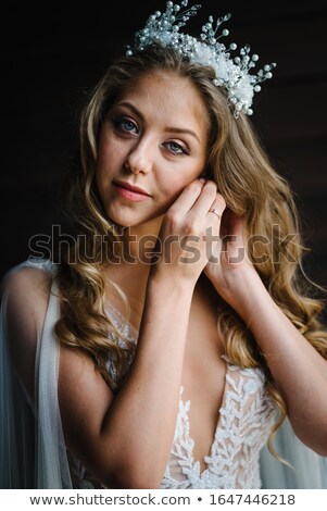 ストックフォト: The Bride In A White Dress Wears Gold Earrings With Pearls