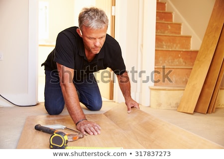 Stock photo: Handyman Laying Floorboards