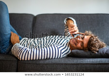 Stock foto: Handsome Young Man Lies On Sofa Indoors