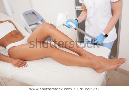 Stockfoto: Beautician Using Laser Machine On Customers Leg