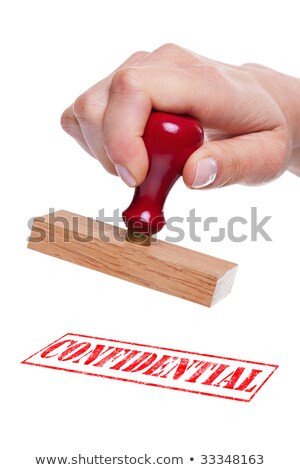 Mano sosteniendo un sello de goma con la palabra confidencial Foto stock © RTimages