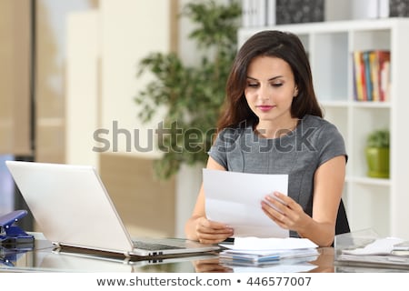 Zdjęcia stock: Smiling Businesswoman Reading Papers In Office