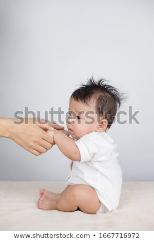 Stok fotoğraf: Cute Toddler Baby Sitting On Moms Hands