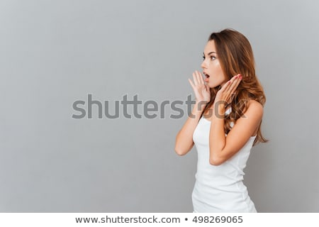 Foto stock: Portrait Of Shocked Woman With Mouth Open Looking Away