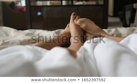 Сток-фото: Feet Of Couple Stretching Out Of Blanket