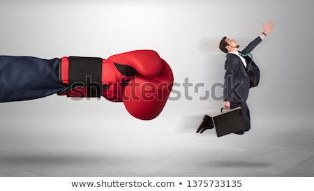 Stok fotoğraf: Giant Hand Gives A Kick To A Small Businessman