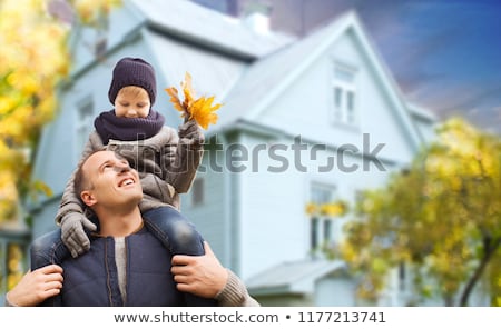 Foto stock: Father And Son With Autumn Maple Leaves Over House