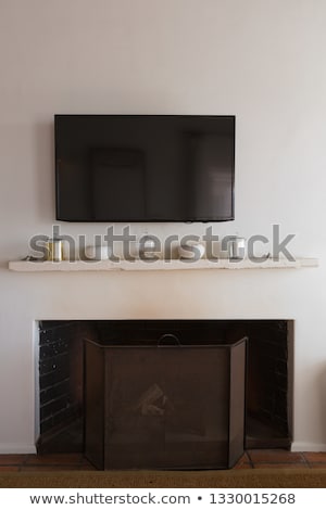 ストックフォト: Front View Of A Wall Television Above Decorative Objects On An Extinct Fireplace At Home