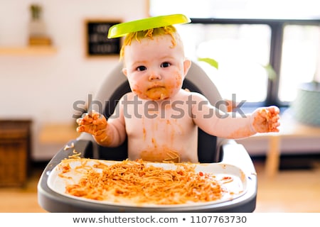 Foto stock: Little Baby Eating Spaghetti Dinner And Making A Mess