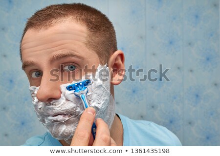 Foto d'archivio: Photo Of Masculine Brunette Guy With Dark Short Hair Shaving His