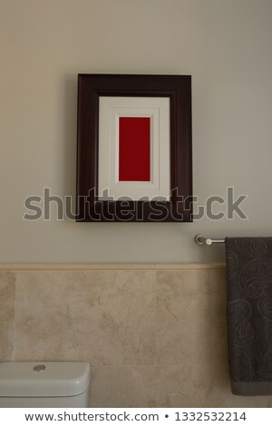 Сток-фото: Front View Of An Empty Frame Fixed On The Wall Above A Towel And A Toilet In Bathroom At Home