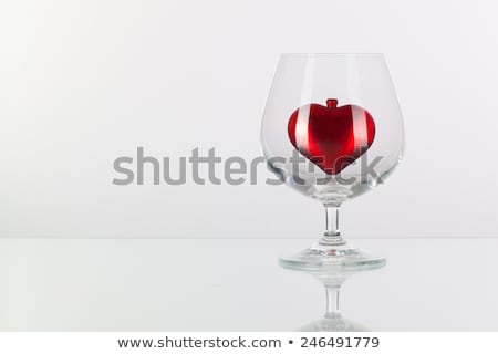 Foto stock: Red Heart Inside A Glass Of Cognac