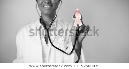 Zdjęcia stock: Smiling Nurse Hold Breast Cancer Awareness Pink Ribbon Wearing Scrubs On A White Background