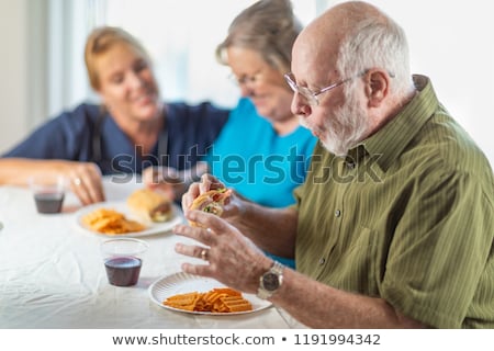 Stockfoto: Female Doctor Or Nurse Serving Senior Adult Couple Sandwiches At