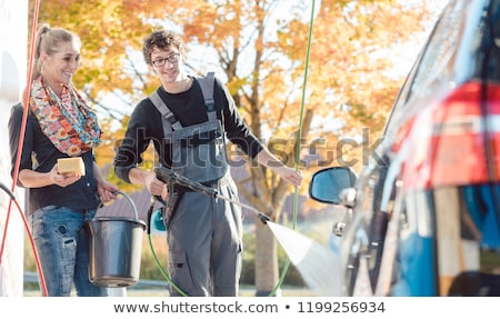 Stok fotoğraf: Service Man Helping Woman Cleaning Her Auto In Car Wash