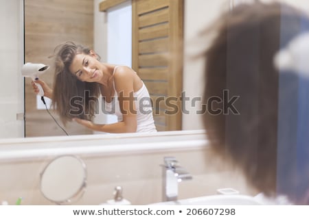 Foto d'archivio: Woman Smiling Through Looking Glass In Her Bathroom